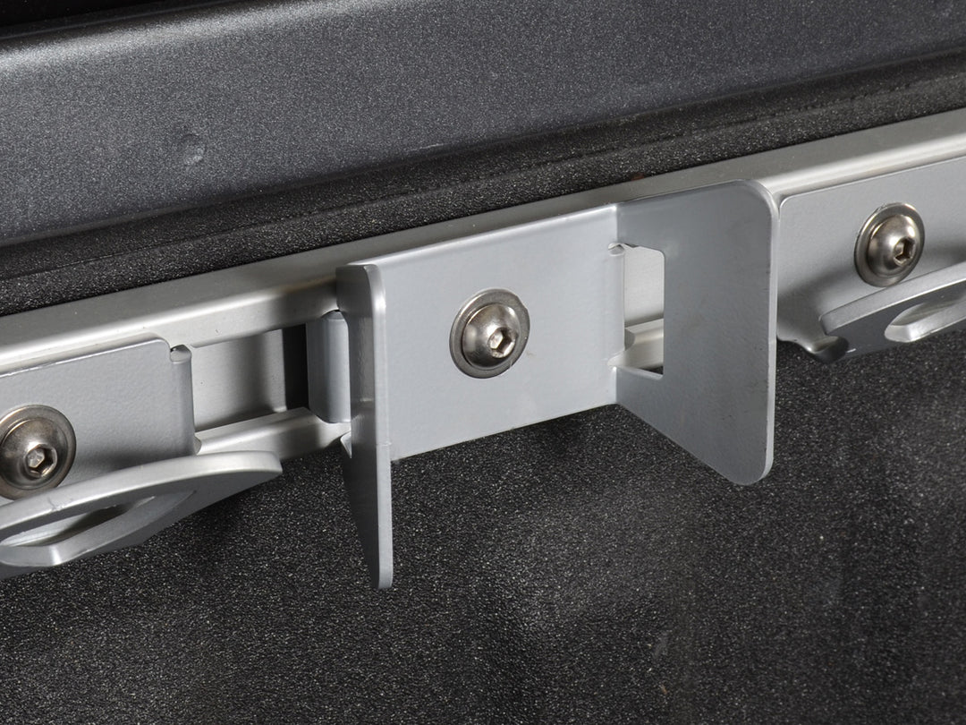 Close-up Nissan Uili-Track Motorcycle Wheel Chock fastened to the track n a truck bed.